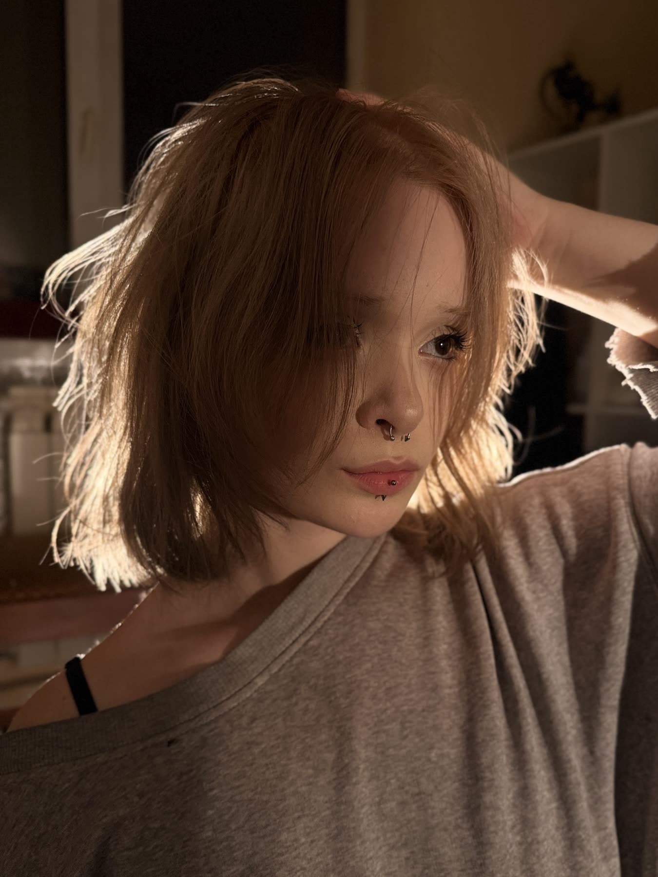 Milana in profile, hand in her hair, warm side light